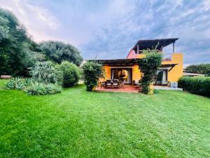 a house with a green yard with a patio at Villa Sole con piscina privata in Cuile Pazzoni