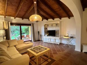 a living room with a couch and a table at Villa Sole con piscina privata in Cuile Pazzoni