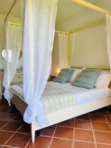 a bedroom with a bed with a canopy at Villa Sole con piscina privata in Cuile Pazzoni +28 photos