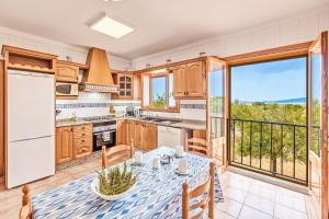 a kitchen with a table and a balcony at Sa Tanca in Pòrtol