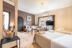 a hotel room with two beds and a living room at Afentika Grand Flat in Archangelos +29 photos