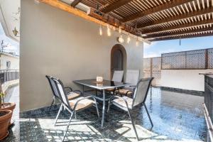 a patio with a black table and chairs at Afentika Grand Flat in Archangelos