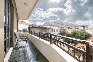 a balcony with a bench and a view of a city at Afentika Grand Flat in Archangelos