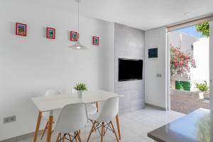 a white dining room with a white table and chairs at Apartamento Princesa Teguise in Tías