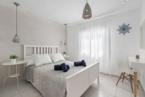 a white bedroom with a bed and a table and a desk at Apartamento Princesa Teguise in Tías +12 photos