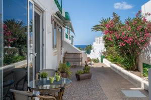 a balcony with a table and chairs and flowers at Apartamento Princesa Teguise in Tías