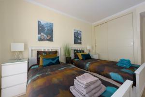 a bedroom with two beds and a dresser at Casares Beach luxe penthouse in Casares +37 photos