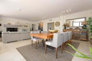 a kitchen and dining room with a wooden table and chairs at Casares Beach luxe penthouse in Casares