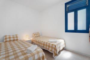 a bedroom with two beds and a window at Apartamentos Playa Azul - 7 in Vallehermoso