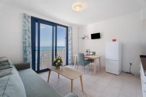 a living room with a couch and a table and a refrigerator at Apartamentos Playa Azul - 7 in Vallehermoso