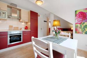 a kitchen with a table with a vase of flowers on it at Fewo Birkenallee - Rose in Deinste