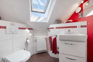 a bathroom with a white toilet and a sink at Fewo Birkenallee - Rose in Deinste +10 photos
