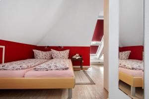 a bedroom with two beds and a red wall at Fewo Birkenallee - Rose in Deinste