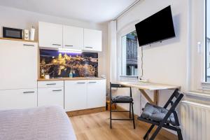 a bedroom with a bed and a desk with a tv at Ferienwohnung Steinstübchen in Bautzen