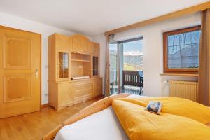 a bedroom with a large bed and a large window at Wohnung Rosengarten Heigler Hof in Collepietra