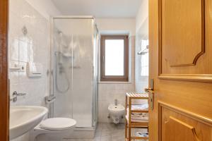 a bathroom with a toilet and a sink and a shower at Wohnung Rosengarten Heigler Hof in Collepietra +23 photos