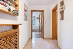 a hallway with white walls and a wooden stairway at Wohnung Rosengarten Heigler Hof in Collepietra
