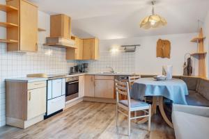 a kitchen with a table with a blue table cloth at Wohnung Rosengarten Heigler Hof in Collepietra