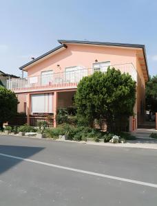 a large pink building with a tree in front of it at Erikbeach Bilo in Bibione