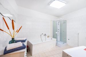 a white bathroom with a tub and a shower at Ferienwohnung Steinstübchen in Bautzen +19 photos