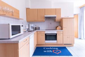 a kitchen with wooden cabinets and a blue floor mat at Appartment Isabelle in Lake Pressegg +34 photos