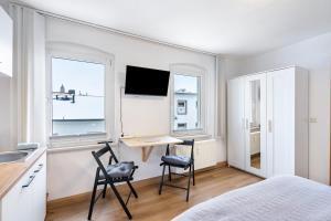 a bedroom with a desk and two chairs in front of two windows at Ferienwohnung Steinstübchen in Bautzen