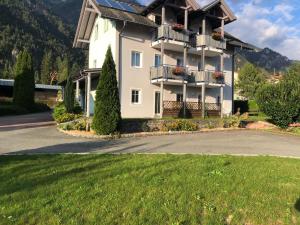a large white house with balconies and a yard at Appartment Isabelle in Lake Pressegg