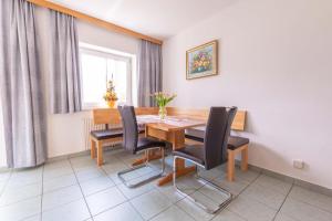 a dining room with a wooden table and black chairs at Appartment Isabelle in Lake Pressegg
