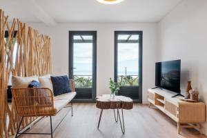 a living room with a couch and a tv at Ocean View Villas in Caniço