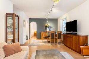 a living room with a television and a dining room at Residenz Malscher Aue in Malsch