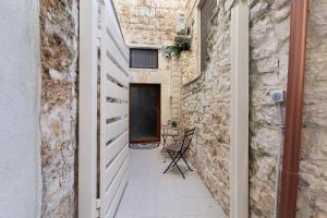 a corridor of an alley with a door and a table at Eclissi suite in Giovinazzo