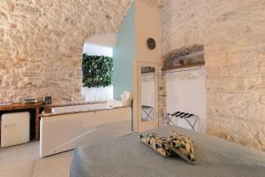 a bedroom with a bed and a stone wall at Eclissi suite in Giovinazzo