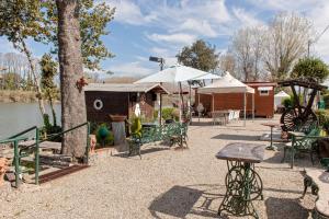 a patio with a table and a building next to the water at Oasis on the river in Marina di Pisa