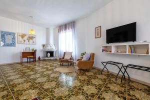 a living room with a flat screen tv and chairs at The Domus vicino ad Alghero in Olmedo