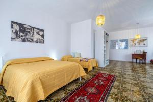 a bedroom with two beds and a red rug at The Domus vicino ad Alghero in Olmedo