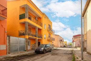 a car parked in front of a yellow building at The Domus vicino ad Alghero in Olmedo