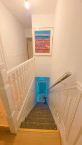a staircase in a house with a painting on the wall at Ascot Room in Slough