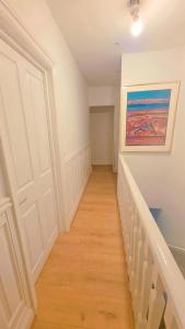a hallway with a staircase with a painting on the wall at Ascot Room in Slough