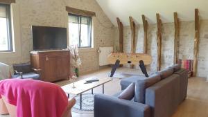a living room with a couch and a flat screen tv at Location Fermette in Goulles