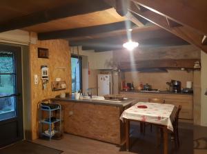 a kitchen with a sink and a counter with a table at Location Fermette in Goulles