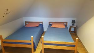 a pair of twin beds in a room at Location Fermette in Goulles +10 photos