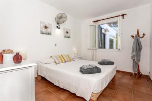 a bedroom with two beds and a window at Sa Sivina in Cala en Bosc