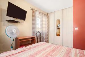 a bedroom with a bed with a fan and a tv at Chambre d'hôtes in Lorgues +12 photos