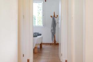 a hallway with a room with a couch and a window at Sa Sivina in Cala en Bosc +21 photos