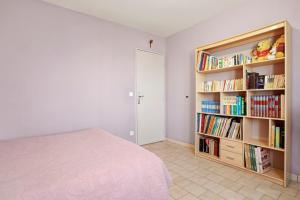 a bedroom with a bed and a book shelf with books at Chambre d'hôtes in Lorgues