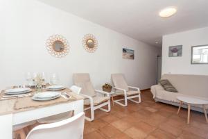 a living room with a table and chairs and a couch at Sa Sivina in Cala en Bosc