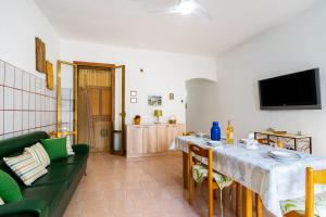 a living room with a table and a green couch at Villetta Lido Canne in Torre Lapillo