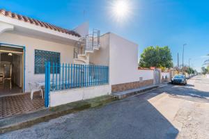 a white house with a blue gate on a street at Villetta Lido Canne in Torre Lapillo
