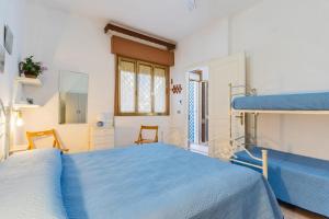 a bedroom with a blue bed and a bunk bed at Villetta Lido Canne in Torre Lapillo