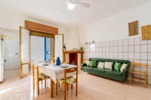 a living room with a table and a green couch at Villetta Lido Canne in Torre Lapillo